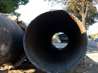 Large metal pipe on a city construction site highlighting urban ecology issues.