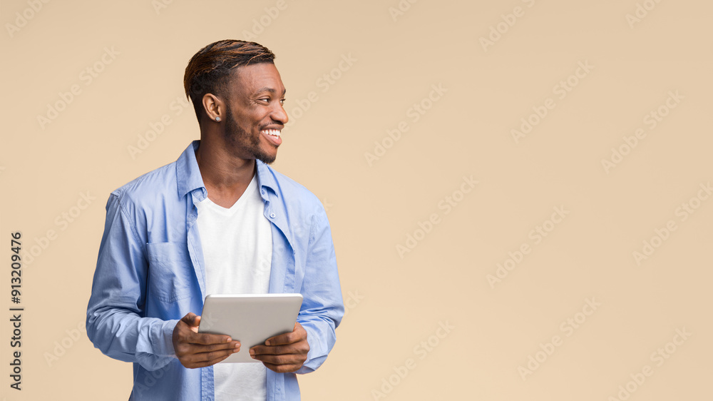 Aufkleber happy african american man holding tablet computer looking aside standing on yellow background in st