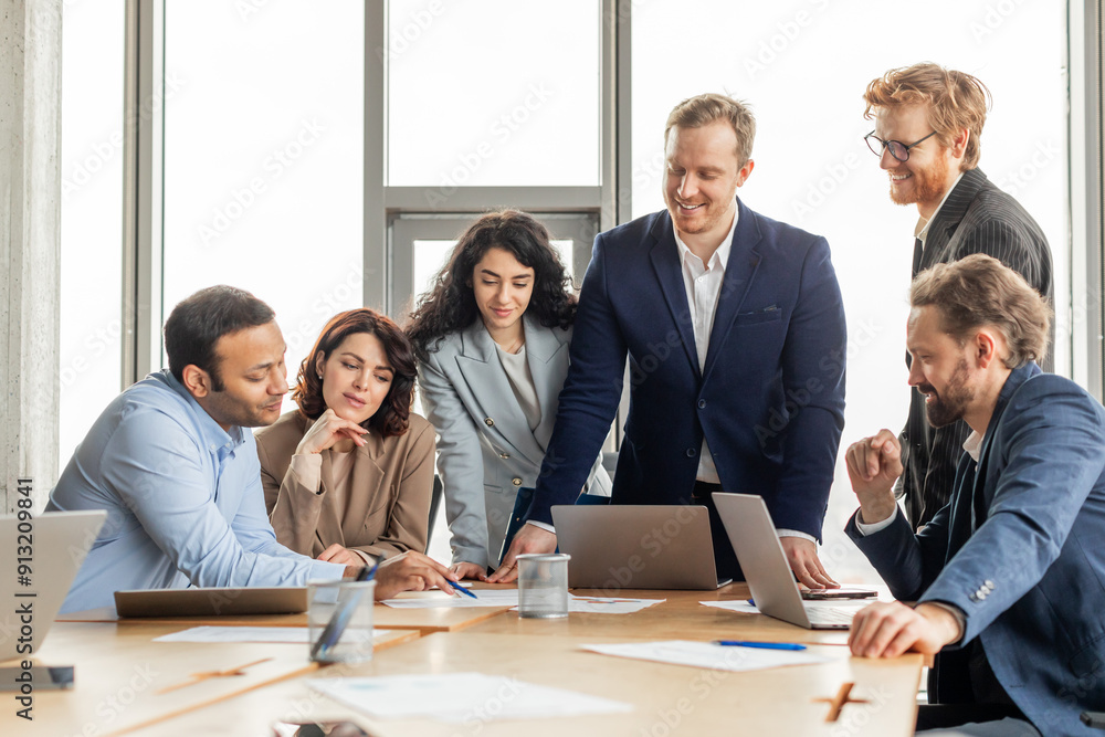 Fototapete a group of diverse business professionals are gathered around a table in a modern office, working to