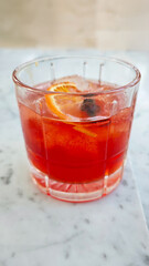 Refreshing Ice Hibiscus Tea in a Glass with Orange Slice on Marble Background in a Cafe