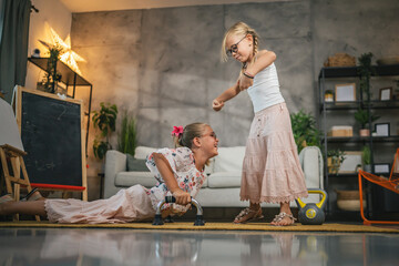 Young girl child play with push up bars on the floor and kettle bell