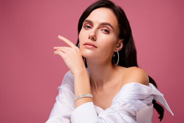 Photo of gentle girl touch face hand wear white shirt precious bracelet isolated pastel color...