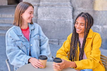 Smiling friends sharing a conversation at an outdoor cafe