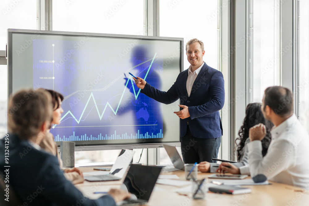 Poster a businessman in a suit stands in front of a large screen, pointing to an upward trending graph. he 