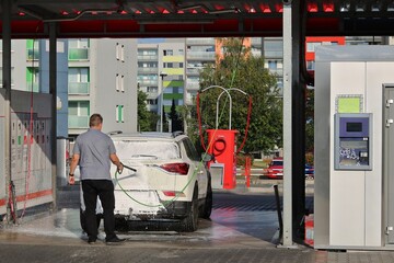 Man washes his car in a hand car wash