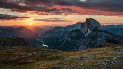 Obraz premium A mountain range with a sun setting in the background