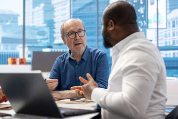 Elderly couple meeting with a financial expert to develop a tailored retirement strategy and...