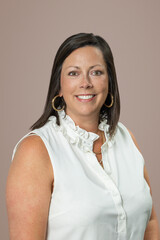 Headshot of Caucasian brunette middle age business woman in studio on beige brown backdrop