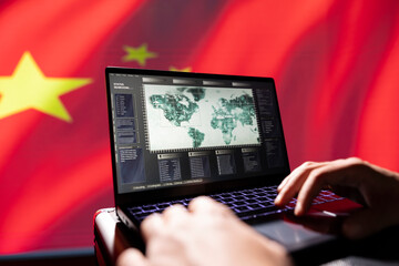 Chinese PSyOp operator using laptop device, making bot accounts attacking Western powers. Close up...