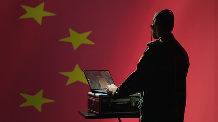 Chinese army military dispatcher looking at surveillance transmission on laptop, relaying...