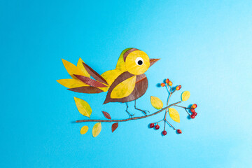 bird made out of leaf on blue background, autumn craft for kid, animal clipart collage made of dry dead leaves, fall DIY,