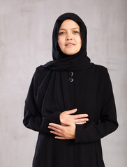 Closeup portrait of young smiling woman in hijab posing in studio