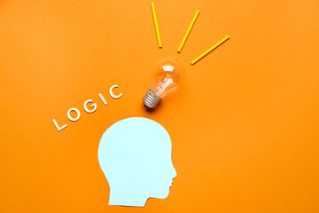 Paper human head with light bulb and word LOGIC on color background