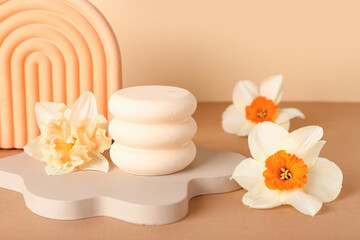 Decorative plaster podiums with flowers on beige background