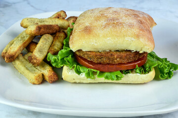  veggie burger  on a ciabatta  bun with veggie fries.