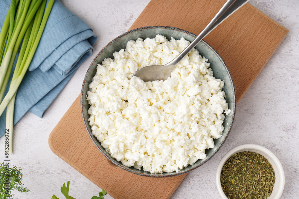 Wall mural bowl with tasty cottage cheese on light background