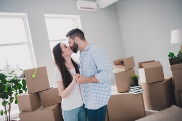 Portrait of two young people cuddle hold arms kiss relocating moving box package new apartment...