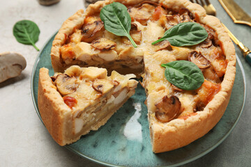 Mushroom pie with spinach leaves and cutlery on green grunge table