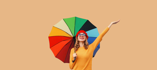 Autumn beautiful happy cheerful young woman holds colorful umbrella enjoys new season in sweater