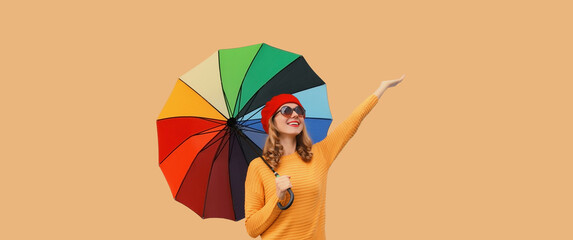 Autumn beautiful happy cheerful young woman holds colorful umbrella enjoys new season in sweater