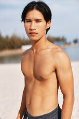 Muscular Asian Athlete Running on the Beach, Exuding Health and Energy in a Serene Outdoor Setting