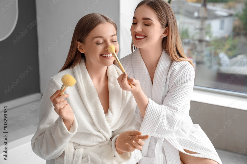 Sticker Young lesbian couple doing makeup in bathroom