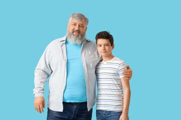 Happy grandfather with his cute grandson on blue background