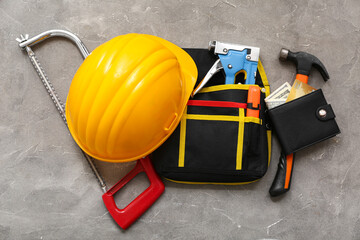 Composition with hardhat, construction tools, wallet and money on grunge background