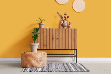 Interior of stylish room with commode and artificial plants
