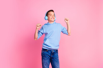 Photo portrait of charming teen boy headphones dancing have fun dressed stylish blue garment isolated on pink color background