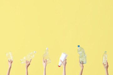 Female hands holding plastic garbage on yellow background. Recycling concept