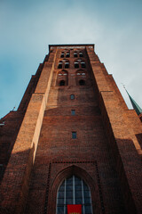 A view looking up at the towering Gothic architecture of St. Mary's Church in Gdansk, Poland
