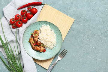 Tasty sweet and sour chicken with rice in plate, vegetables and fork on turquoise grunge background