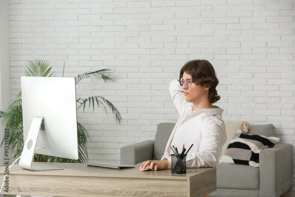 Aufkleber male programmer in eyeglasses working with computer at workplace in office