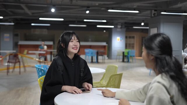 A Taiwanese woman and a South Asian woman in their 20s chatting amicably in a university cafeteria in Da&rsquo;an District, Taipei City, Taiwan.&nbsp;
