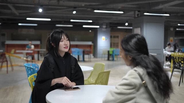 A Taiwanese woman and a South Asian woman in their 20s chatting amicably in a university cafeteria in Da&rsquo;an District, Taipei City, Taiwan.&nbsp;