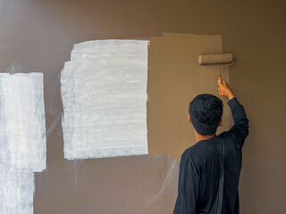 The painter is painting a new wall to cover the repairs.