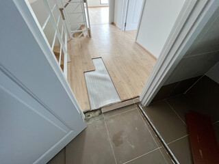 The laminate flooring in the room was damaged due to water penetrating the wood for too long.