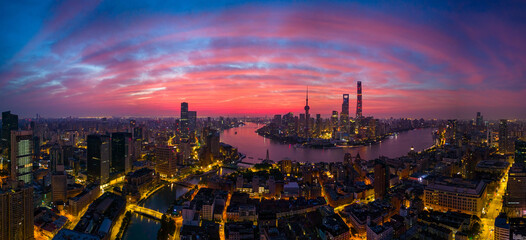 Aerial view of modern city skyline and burning clouds at sunrise in Shanghai.