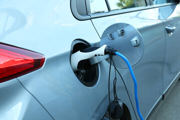 Charging modern electric car from station outdoors