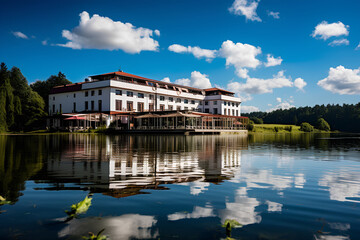 a hotel with a lake and blue sky.
