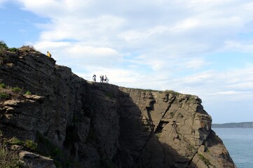 Tourists on the edge of Cape Tobizina. Russian Island. Primorsky Krai