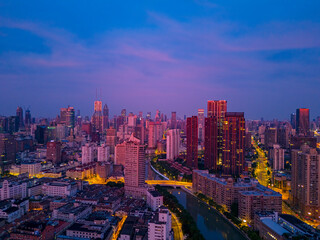 Aerial view of modern city skyline and burning clouds at sunrise in Shanghai.