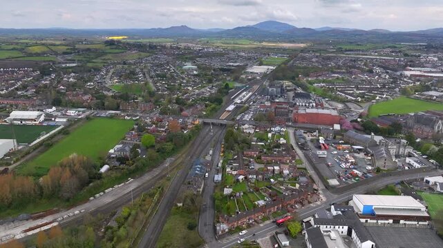 Dundalk, County Louth, Ireland, April 2023. Drone approaches Dundalk Railway Station with the Ring of Gullion and Mourne Mountains of Ulster and Northern Ireland in the distance.