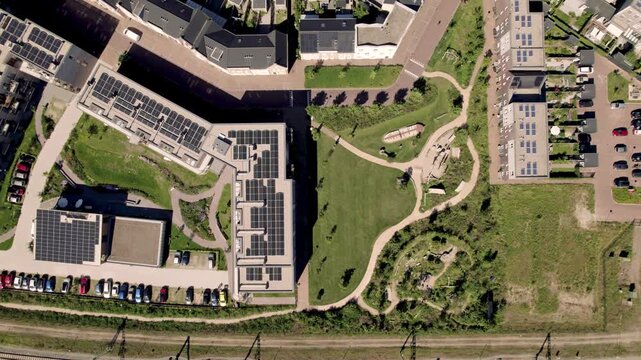 Aerial showing Dutch residential urban development and infrastructure of Noorderhaven neighbourhood in Zutphen, The Netherlands, seen from above with rooftops full of solar panels and parked cars