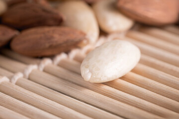 Several almonds on a wooden background with soft lighting, selective focus.