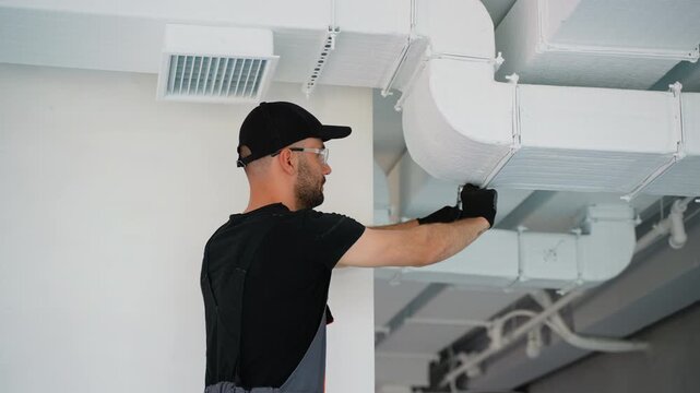 Hvac worker install ducted pipe system for ventilation and air conditioning in office