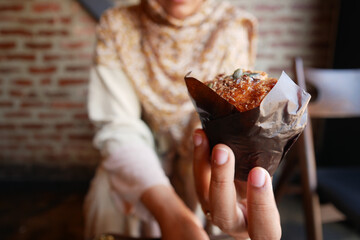 woman holding a tasty muffin 