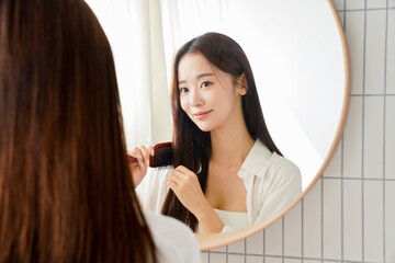 ヘアケアをする美しい若い女性