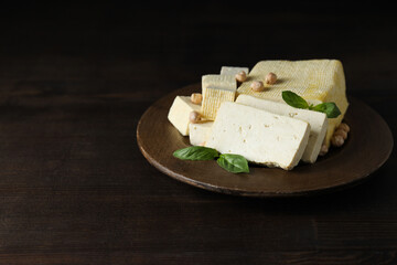 Tofu in a wooden bowl on a dark background